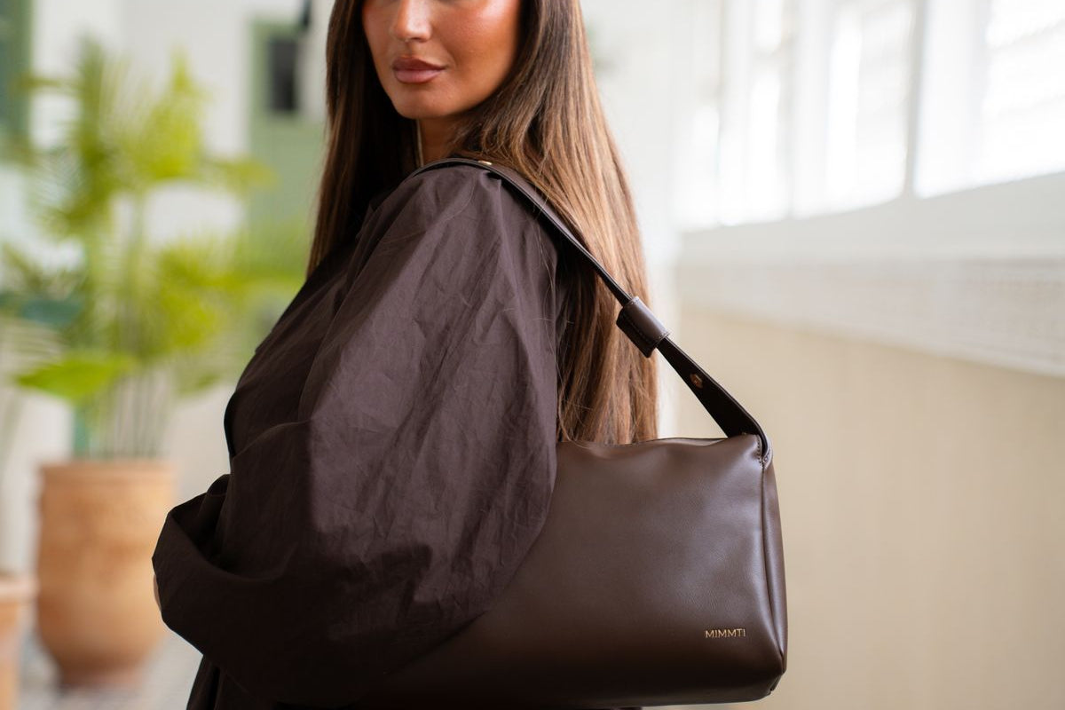 Luiertas als handtas: vrouw draagt de MIMMTI Amara in espresso