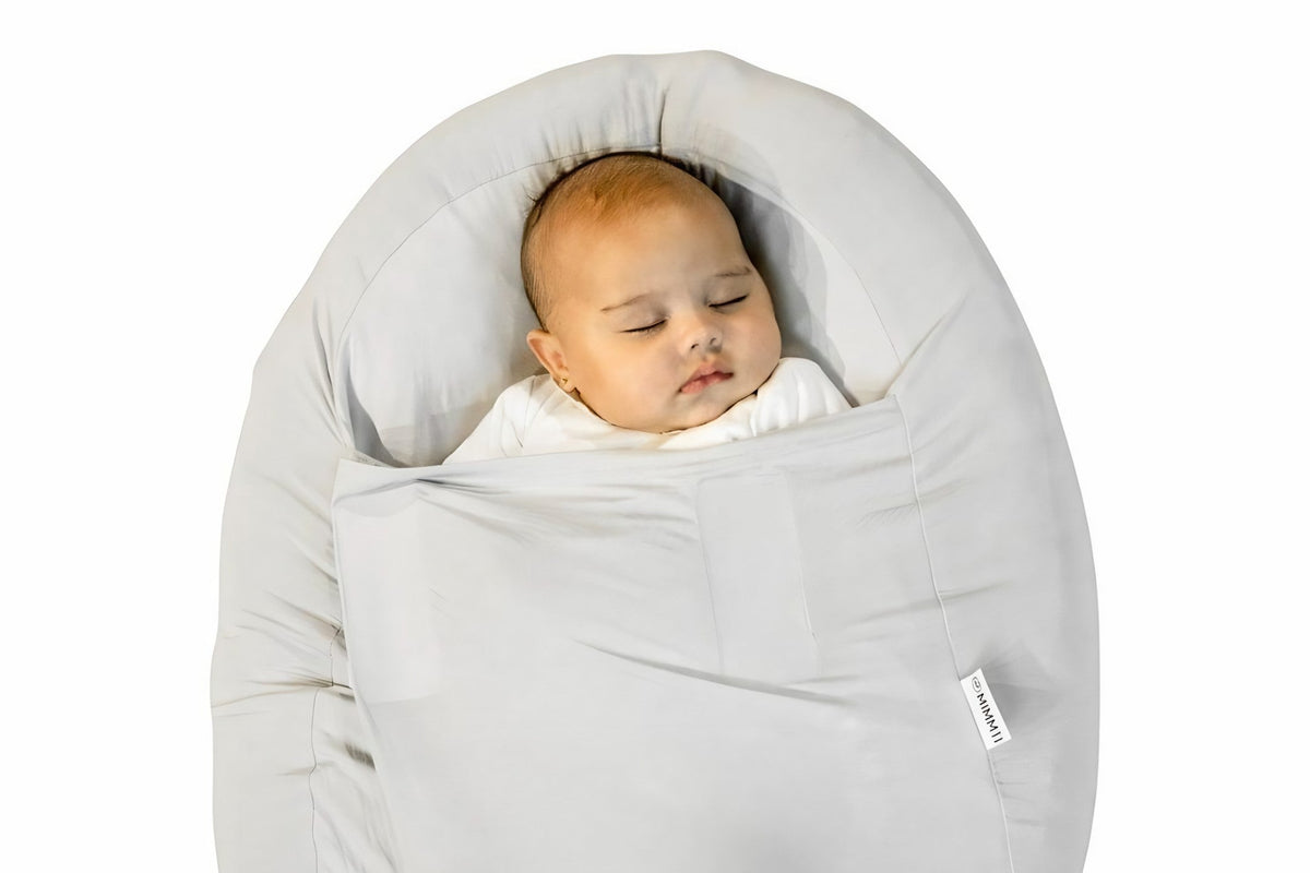 Babynestje van voedingskussen: baby ingebakerd in de MIMMTI Sleepynest