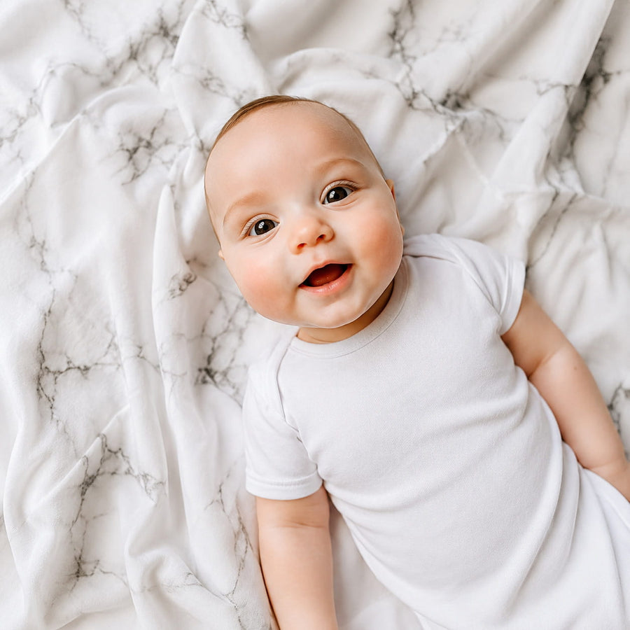 Baby op de MIMMTI hydrofiele doek met marmerprint