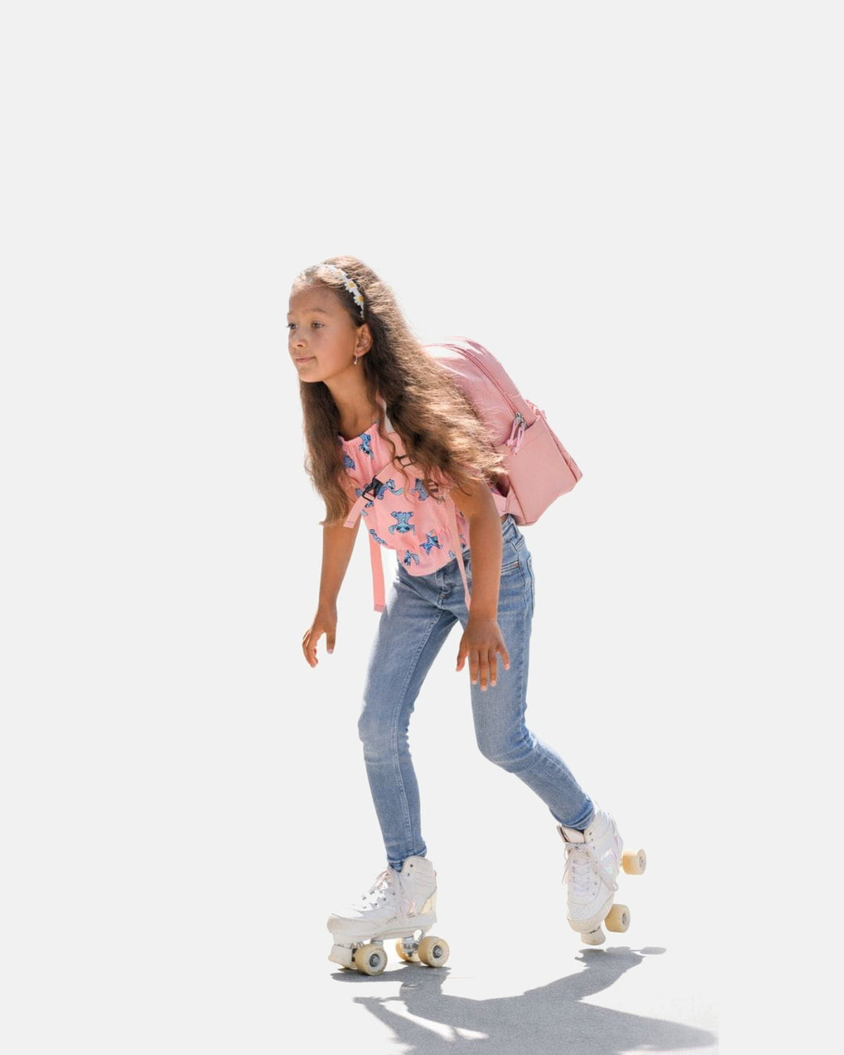 Kind op rolschaatsen draagt de MIMMTI Kids Bag kinderrugzak in dusty roze