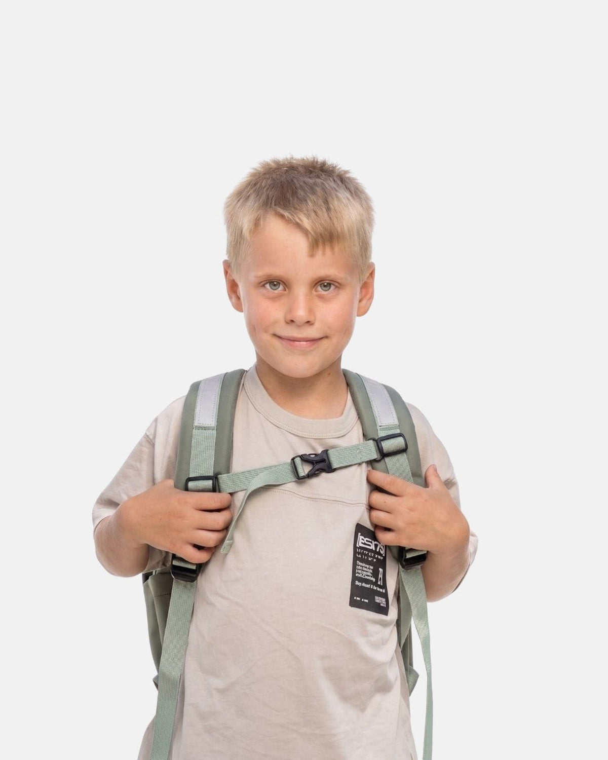 Kind draagt de MIMMTI Kids Bag kinderrugzak in mintgroen, vooraanzicht met borstband