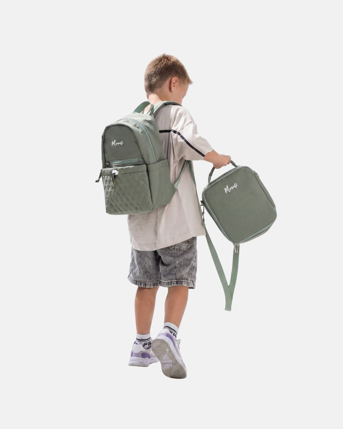 Kind draagt de MIMMTI Kids Bag kinderrugzak in mintgroen met lunchbag in de hand