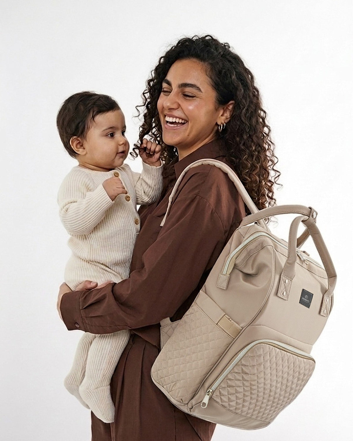 Moeder met baby op de arm, MIMMTI 1.0 luiertas rugzak in beige taupe