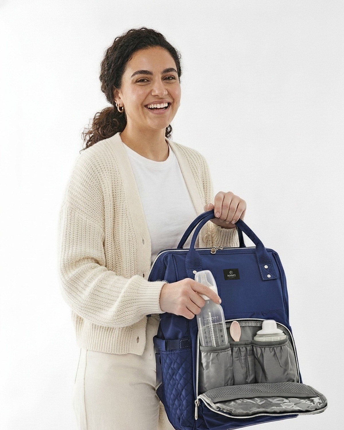 Blauw · Moeder pakt een flesje uit de MIMMTI 1.0 luiertas rugzak in blauw