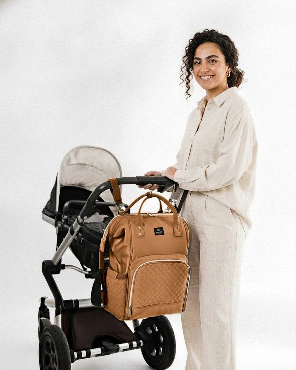 Cognac · Moeder bij de kinderwagen met de MIMMTI 1.0 luiertas rugzak in cognac