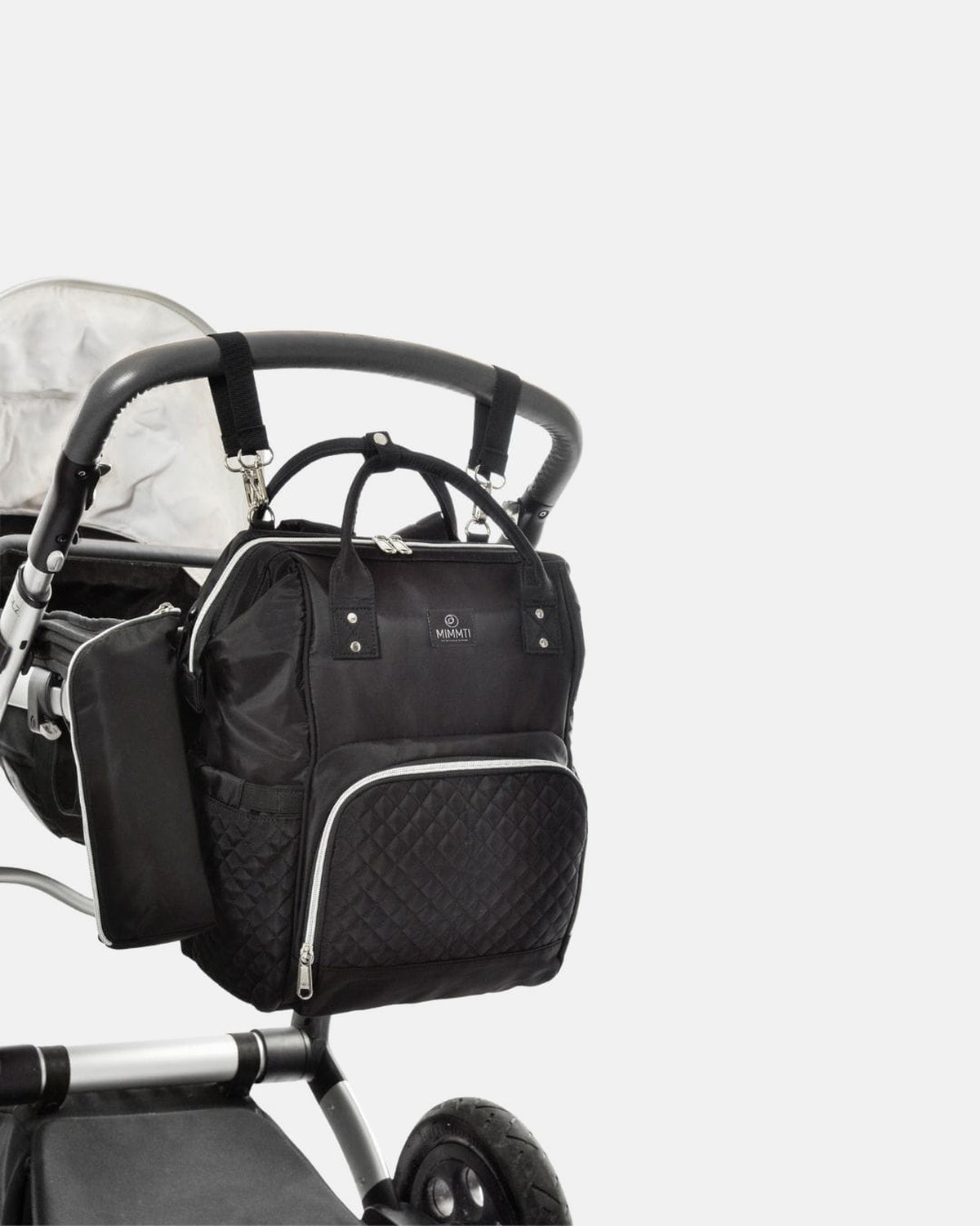 MIMMTI 1.0 luiertas rugzak in zwart aan de kinderwagen met kinderwagenclips