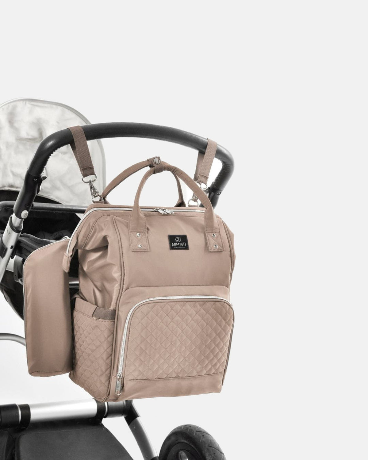 MIMMTI 1.0 luiertas rugzak in beige taupe aan de kinderwagen met kinderwagenclips