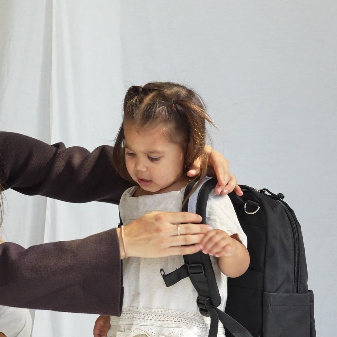 Kind krijgt de MIMMTI Kids Bag kinderrugzak in zwart om, borstriem en schouderbanden