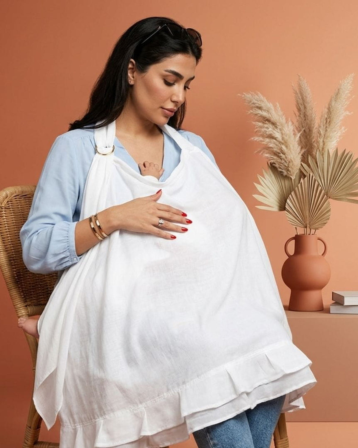Moeder voedt haar baby onder de MIMMTI voedingsdoek ivory, zicht via de balein
