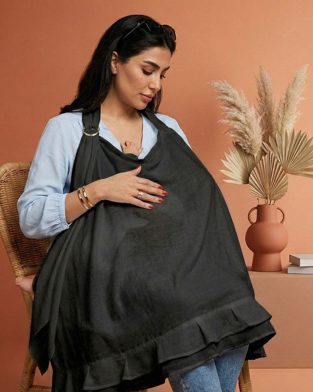 Moeder voedt haar baby onder de MIMMTI voedingsdoek zwart, zicht via de balein