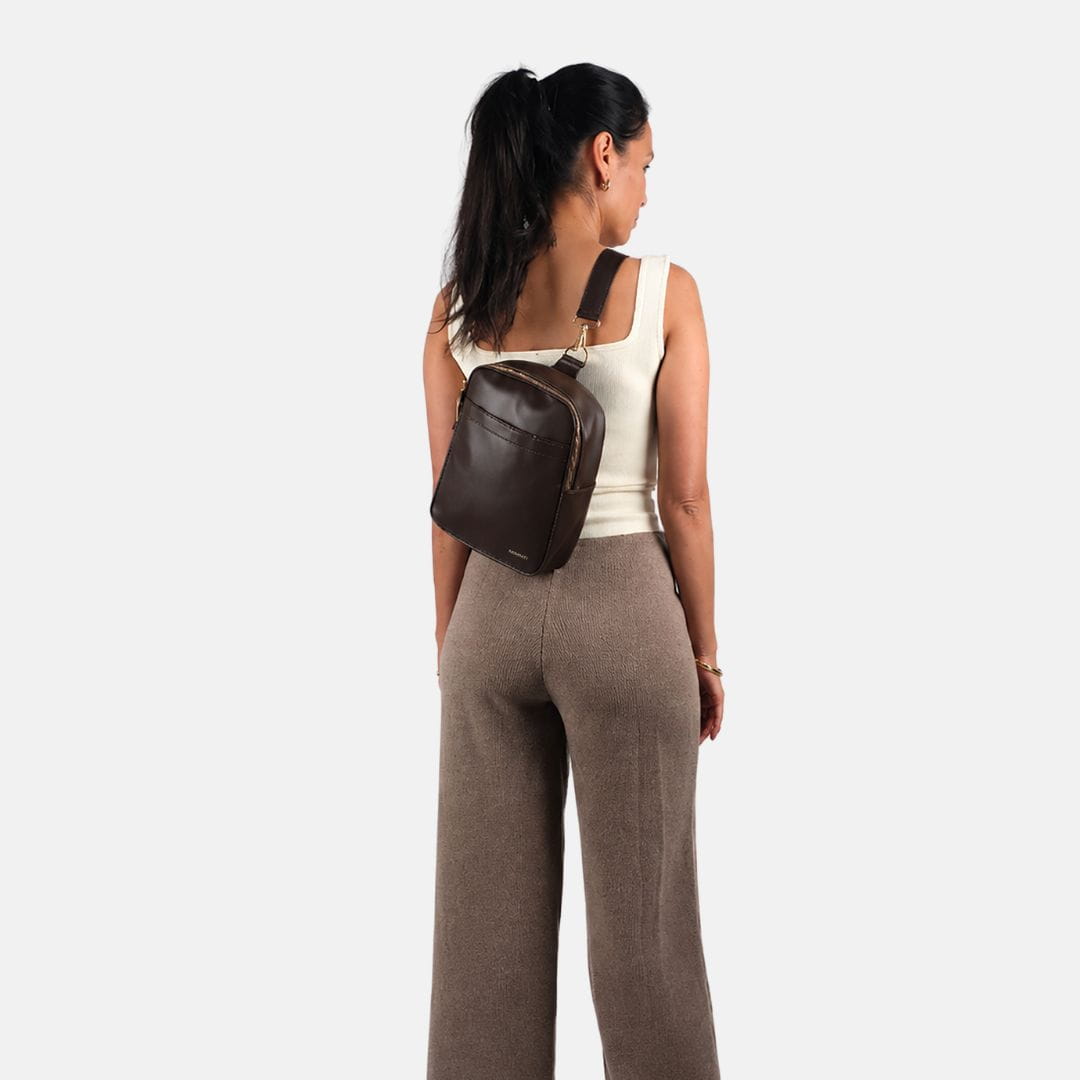 Vrouw draagt de MIMMTI Zoya luiertas in espresso crossbody op de rug