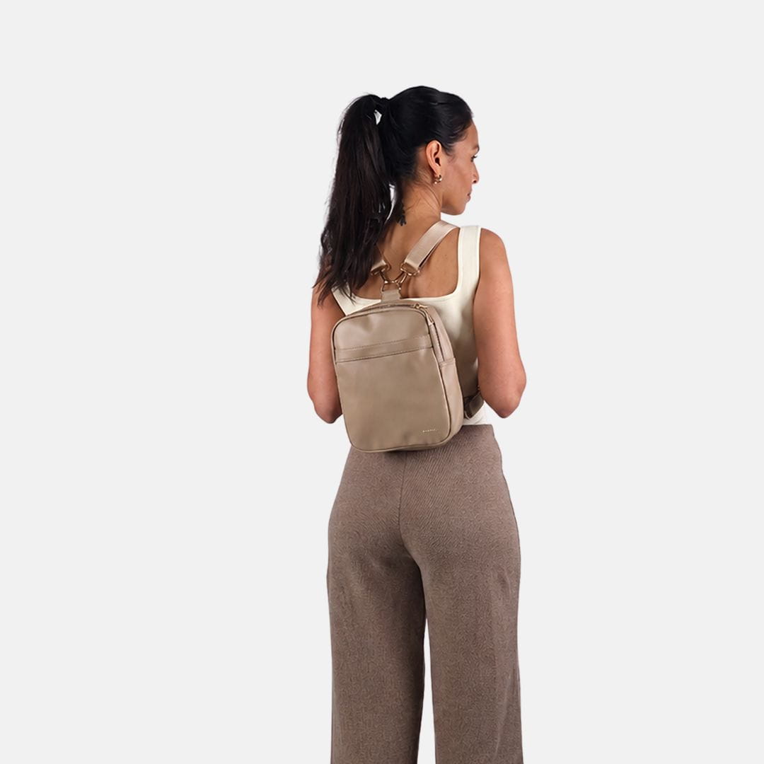Vrouw draagt de MIMMTI Zoya luiertas in sand als rugzak