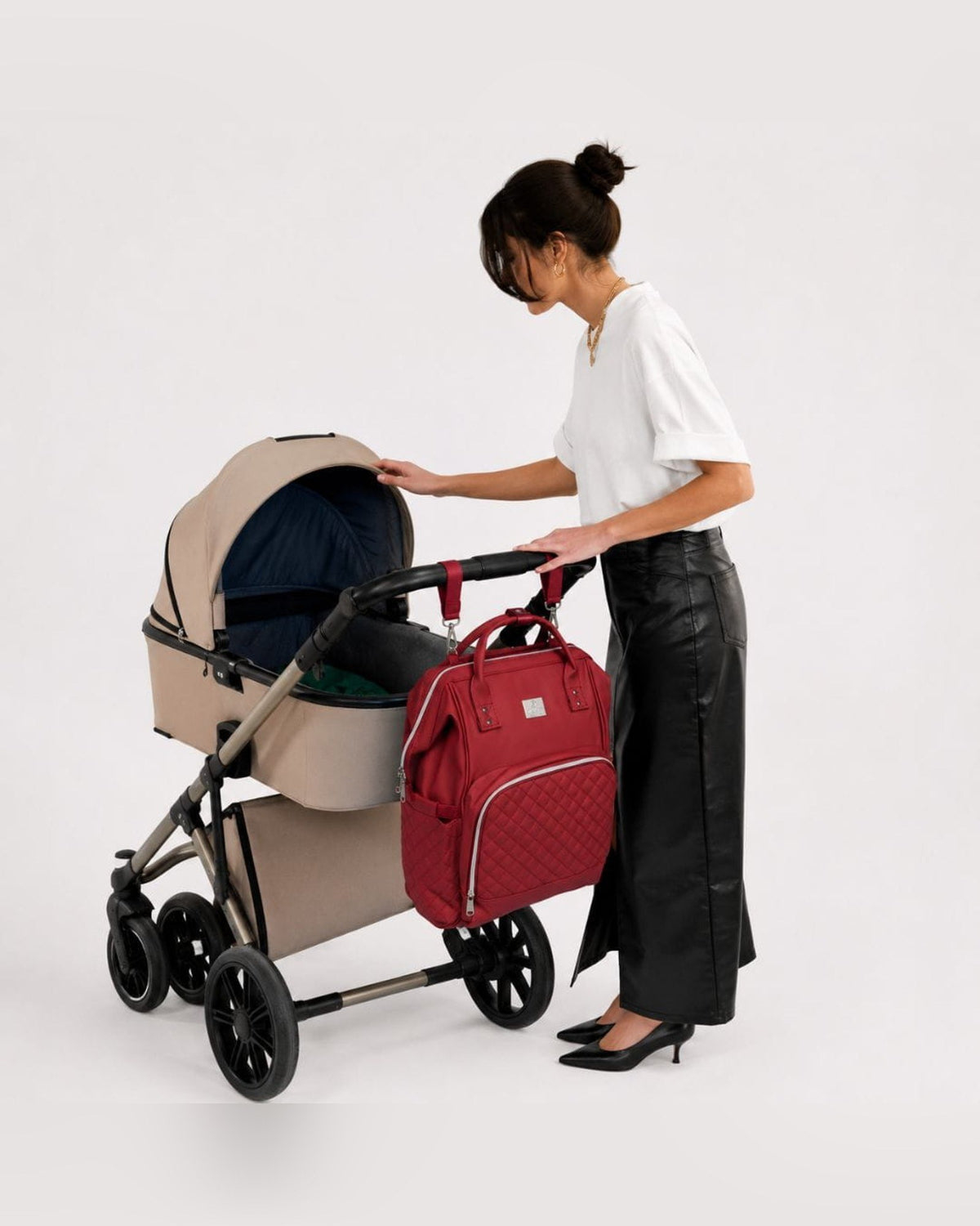 Vrouw met kinderwagen, MIMMTI 2.0 luiertas rugzak in cherry aan de duwstang