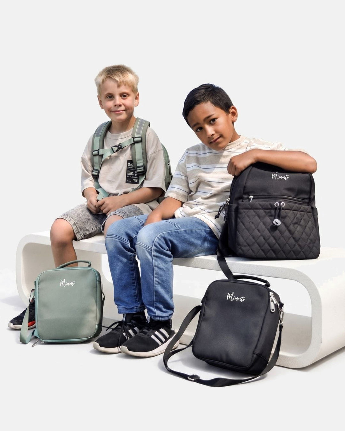Twee kinderen met de MIMMTI Kids Bag kinderrugzak in zwart en mintgroen