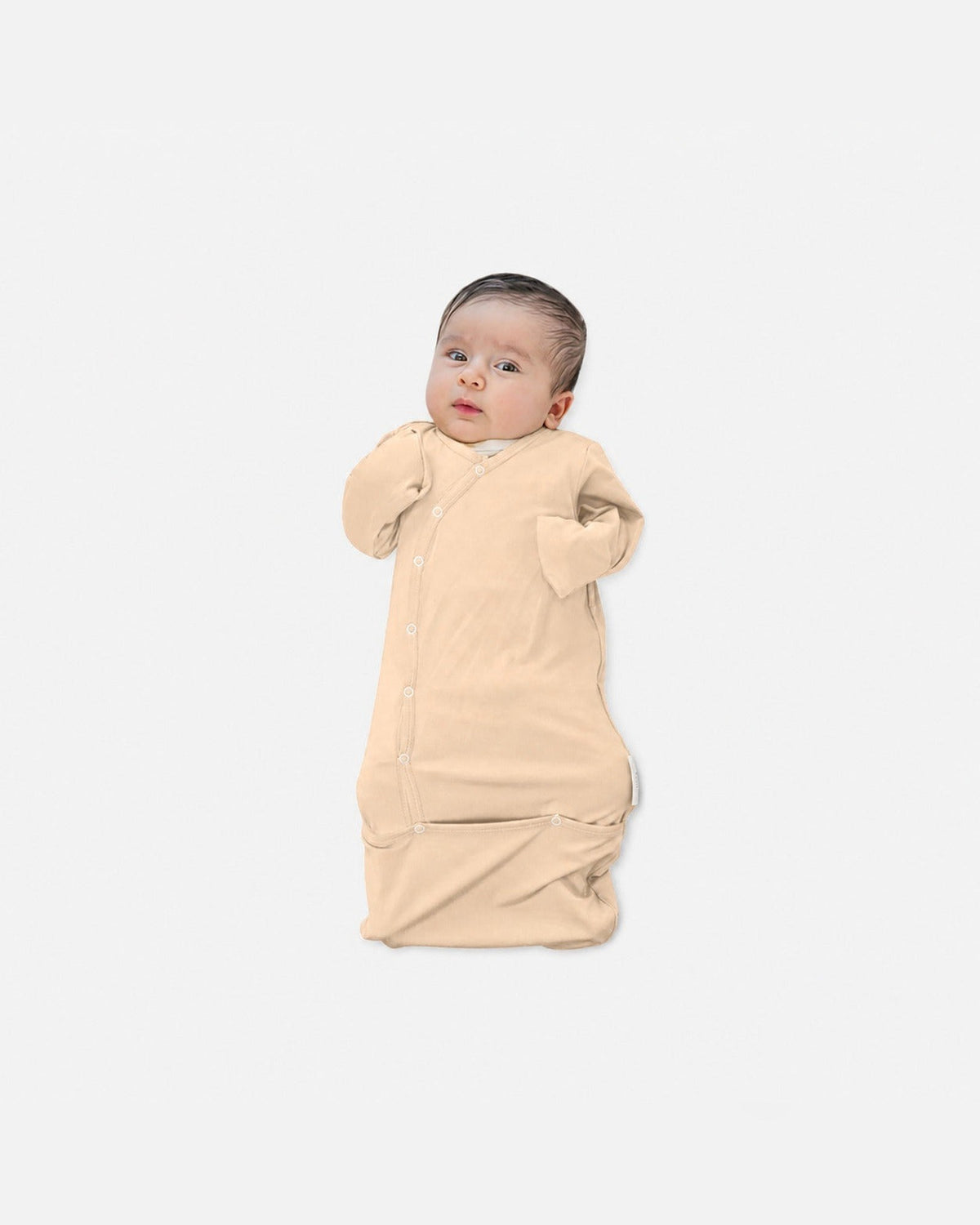 Baby in de MIMMTI SleepyBeebi onesie met trappelzak in beige