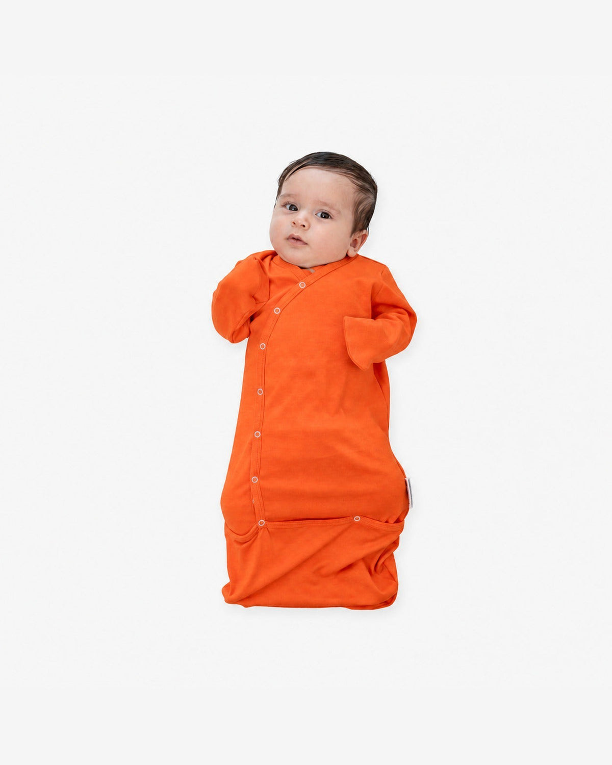 Baby in de MIMMTI SleepyBeebi onesie met trappelzak in cognac