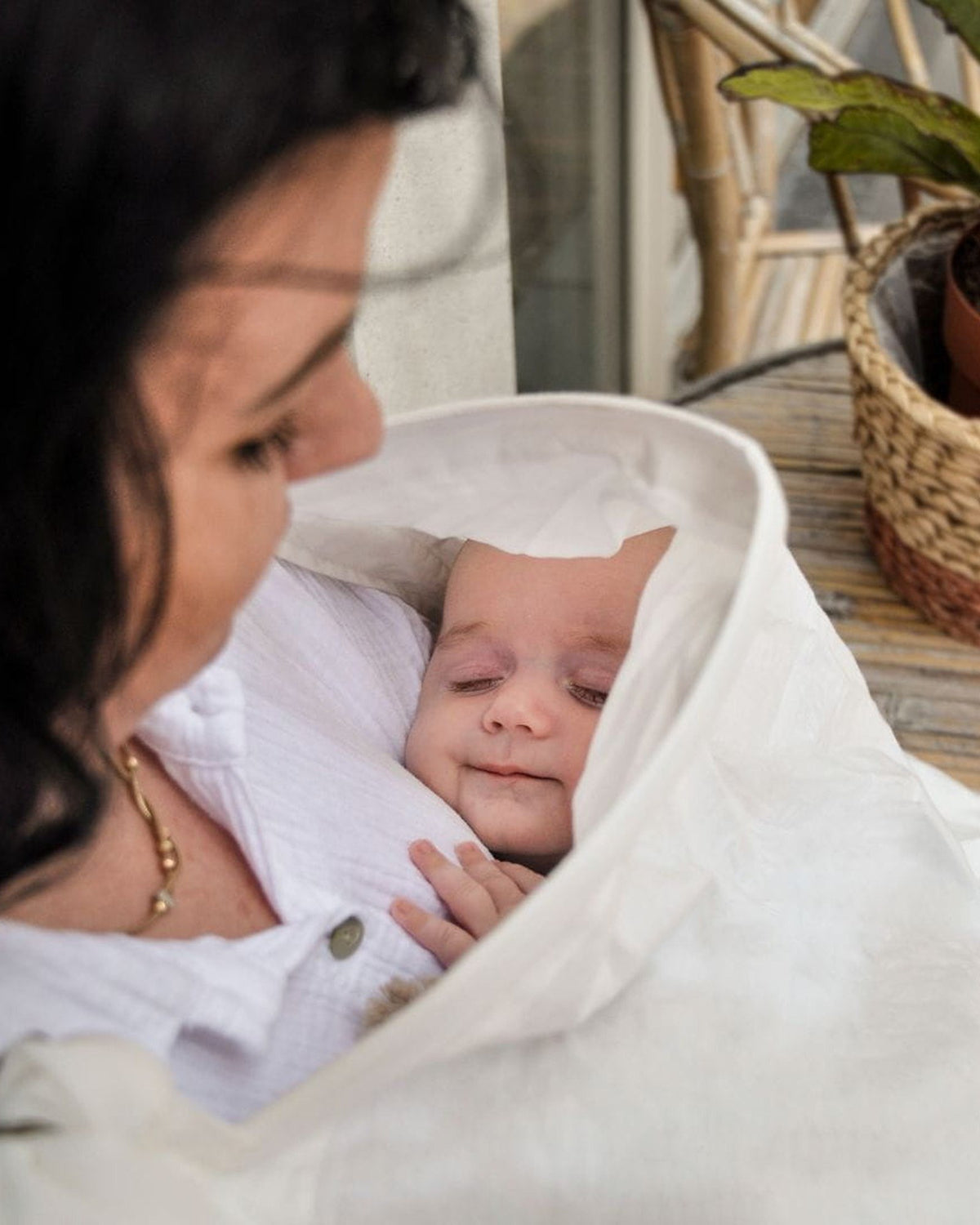 Moeder kijkt naar haar baby onder de MIMMTI voedingsdoek in ivory