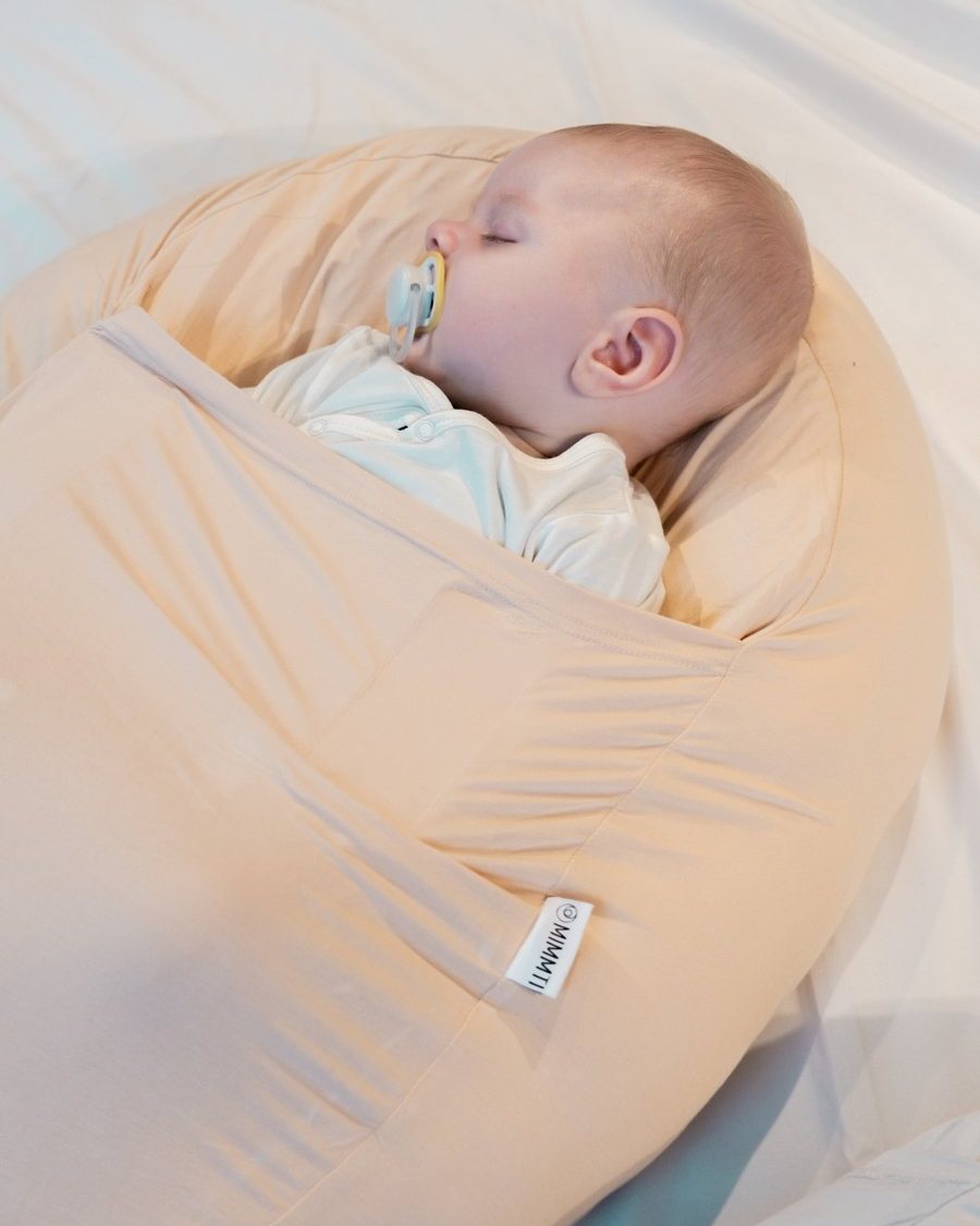 Slapende baby met speen in een MIMMTI Sleepynest