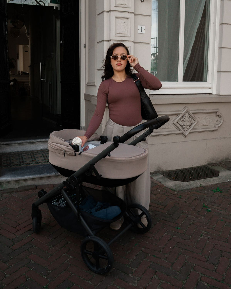 Moeder met kinderwagen voor de deur