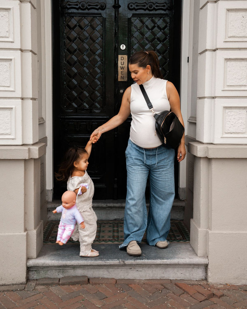 A mother steps out of the door with her daughter, carrying the MIMMTI Zoya